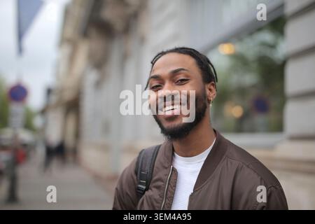 Happy young Black man smiling on a city street Stock Photo