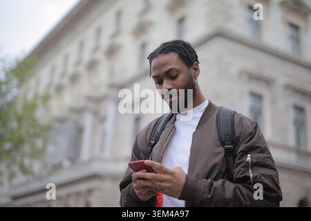 Young black man looking at his smartphone outdoors Stock Photo