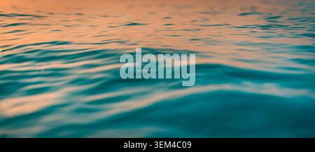 Teal ocean surface swells soft afternoon light. Smooth rolling waves calm liquid texture. Serene blue green surface soothing natural backdrop Stock Photo