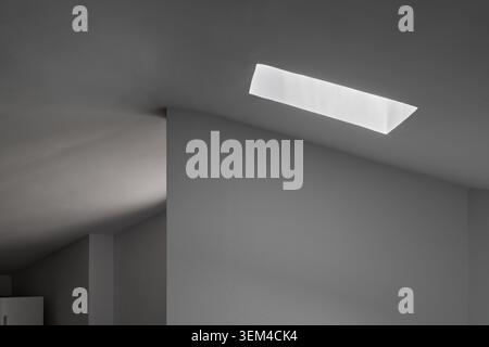 Light entering through the skylight of a house creating an abstract scene of light and shadow. Stock Photo