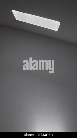 Light entering through the skylight of a house creating an abstract scene of light and shadow. Stock Photo