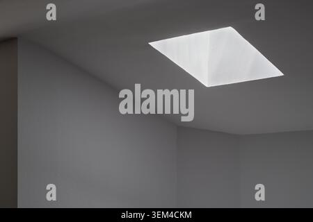 Light entering through the skylight of a house creating an abstract scene of light and shadow. Stock Photo