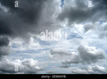 Mostly cloudy sky with storm clouds at the top, scattered small patches of blue sky, thick and thin cloud areas Stock Photo