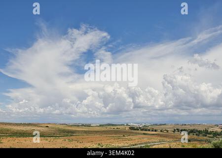 Dramatic cumulus clouds over dry farmland and rolling countryside in rural Spain. Stock Photo