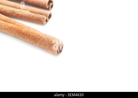 Top view horizontal closeup of dry brown cinnamon sticks arranged diagonally on white copy space background Stock Photo