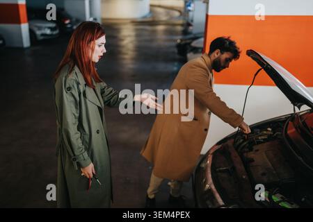 inspecting car engine in parking garage after a breakdown, woman looking frustrated Stock Photo