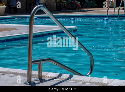 An inground pool handrail at a community swimming pool Stock Photo
