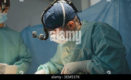Man surgeon working doing operation with medical team assistants practitioner physician in medical uniform doctor work in clinic modern surgical Stock Photo
