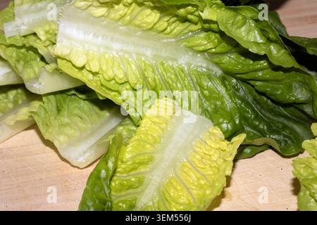 Close up of baby gem lettuce leaves on a wooden chopping board Stock Photo