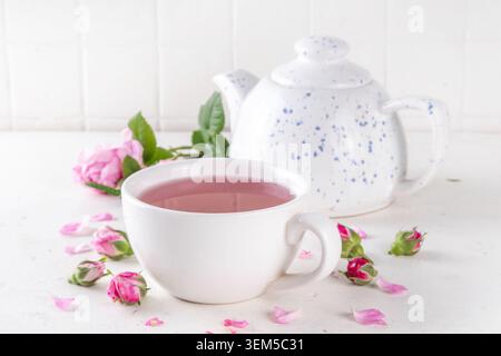 Healthy non caffeine drink, herbal rose tea with fresh organic rose petals, hot infused tea beverage on white background copy space Stock Photo