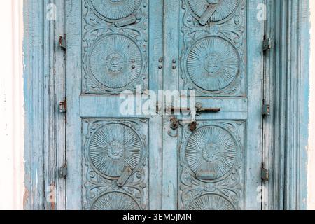 A close-up of a traditional carved wooden door painted in a light blue color on an old heritage building in Fort Kochi; Kerala, India Stock Photo