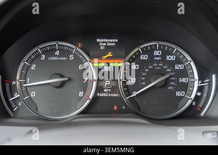 A close-up photograph of a modern vehicle instrument cluster screen displaying a Maintenance Due Soon B1 service reminder with a bright yellow wrench Stock Photo