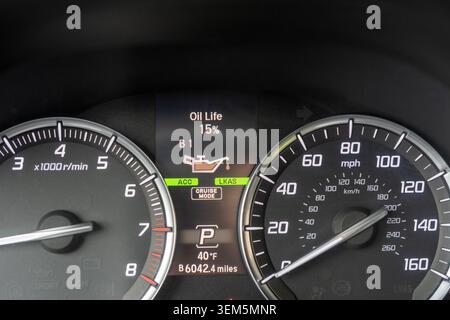 A close-up photograph of a modern vehicle instrument cluster digital screen displaying an Oil Life 15% and B1 service reminder with an oil can icon. T Stock Photo