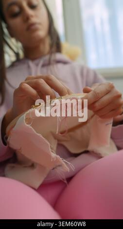 Closeup of hand sewing plush fabric with care and precision Stock Photo