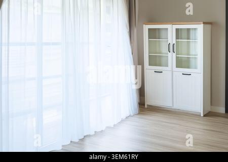 White bookcase with black handles in a room, close-up. Stock Photo