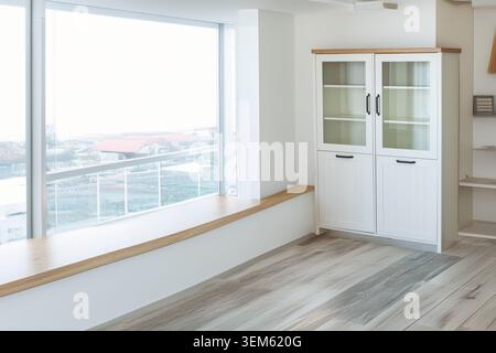 White bookcase with black handles in a room, close-up. Stock Photo