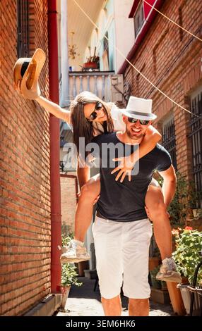 Joyful middle aged couple friends having fun together enjoying vacation on old city street.Carefree married couple in love having fun enjoying time to Stock Photo