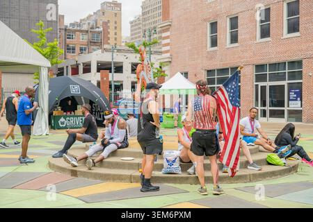 Memphis, United States, MAY 23, 2026 - Athletes and spectators rest on concrete steps in an urban plaza in downtown Memphis, Tennessee, with a man hol Stock Photo