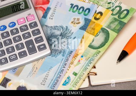 Calculator, notebook, Philippine peso. Financial concept. Close up Stock Photo