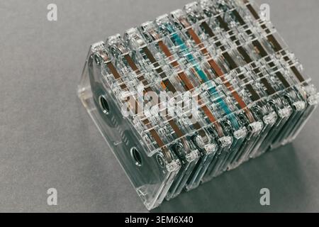 Row of transparent vintage audio cassettes stacked together on dark background. Retro music archive and analog collection concept Stock Photo