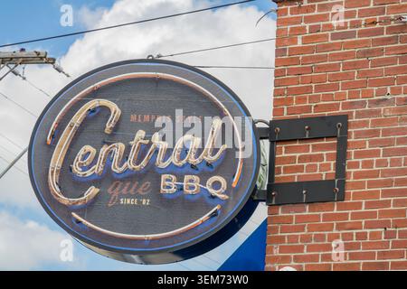 Memphis, Tennessee, United States, MAY 24, 2026 - Circular neon sign for Central Que BBQ mounted on a red brick wall against a blue sky with clouds. Stock Photo