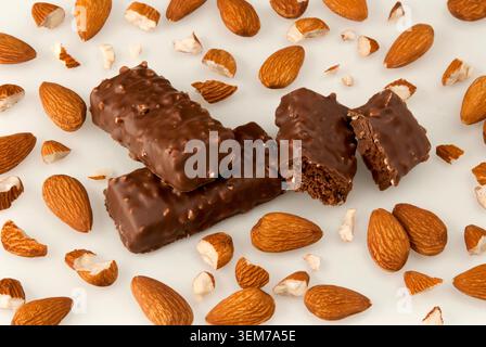A sweet composition of dark chocolate, a whole medal, and grated chocolate on a white background. Close-up front view. Stock Photo