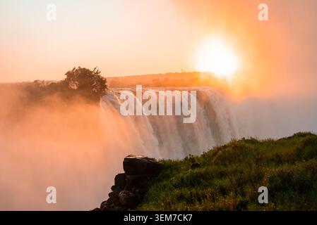 Victoria Falls at dawn with Zambezi River plunging over basalt cliff Stock Photo