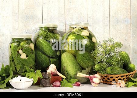Homemade pickling recipe, cucumbers and pickling ingredients, Pickled cucumbers in jars with garlic and dill on wooden kitchen table, rustic pickling Stock Photo