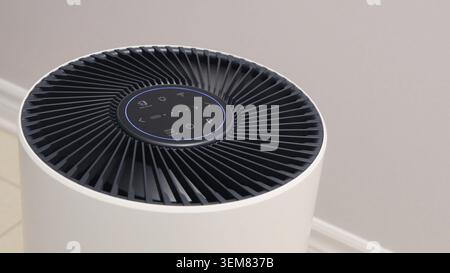Close up view of Air Purifier with Black Fan. Black Round Electronic Device with Buttons and Bright Lights on White Background Stock Photo