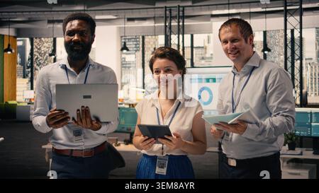 Portrait of work team analyzing data analysis results and KPI metrics in corporate workspace. Diverse business people collaborating on strategy, performance reporting and development. Stock Photo