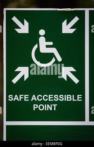 Close-up of a safe accessible point sign featuring a wheelchair symbol and directional arrows. Represents accessibility, emergency planning, inclusive Stock Photo