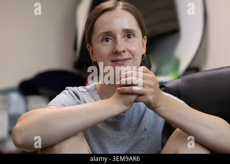 Excited Young Woman Celebrating Success at Home with Raised Fist and Joyful Expression Stock Photo