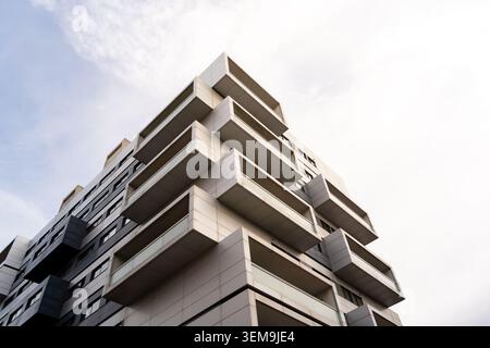 Modern residential building featuring a facade with many geometric balconies and a clear sky Stock Photo