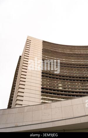 Modern brutalist architecture featuring concrete surfaces, curved forms, and repetitive window patterns Stock Photo