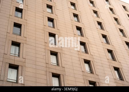 Modern building facade featuring many windows creating a symmetrical pattern Stock Photo
