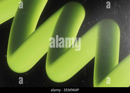 Bright neon green 3D spiral spring shape on dark background with vintage film grain dust and retro scratches Stock Photo