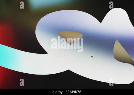 Abstract white geometric cutout shape over colorful blurred background with film scratches overlay Stock Photo