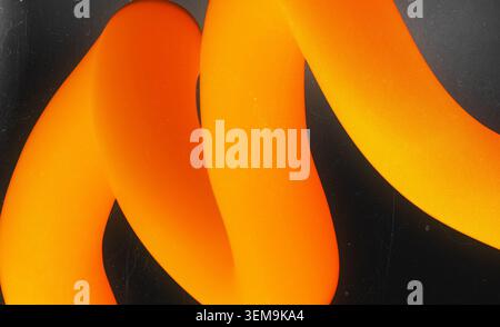 Abstract flowing orange 3D shape on a dark textured background Stock Photo