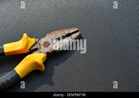 Rusty Hand Pliers on Black Textured Background Stock Photo