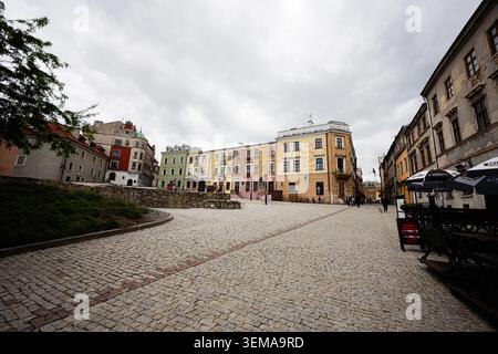 Lublin, Poland - May 13, 2026: Empty cobblestone square lined with pastel historic buildings and outdoor cafes in Lublin old town. Stock Photo