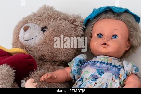 Close-up of antique teddy bear and doll on plain white background Stock Photo