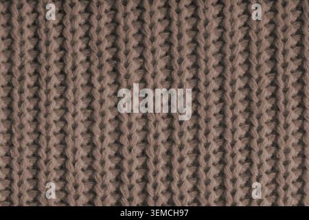 Close up, macro of brown knitted fabric texture with visible yarn stitches and soft wool pattern. Cozy textile backdrop, cloth background, fashion wal Stock Photo