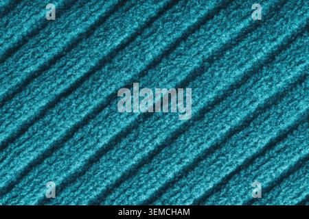 Close up, macro of turquoise colored knitted fabric with diagonal relief ribbed pattern and soft wool texture. Detailed textile surface, knitwear back Stock Photo