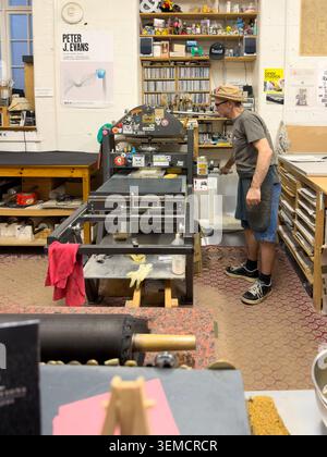 Artist working with an etching press in a printmaking studio workshop Stock Photo
