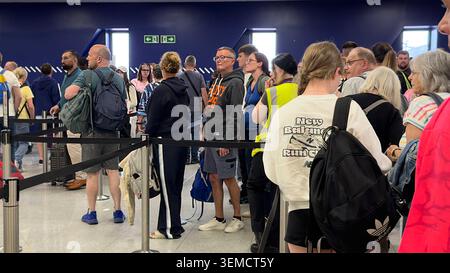 People standing in long queue at newcastle airport terminal waiting for check-in security clearance Entry Exit system EES frustration delays passport Stock Photo