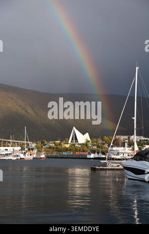 View of a Rainbow over the Arctic Cathedral and Tromsøbrua from Tromsø Harbour towards Tromsdalen, Northern Norway Stock Photo