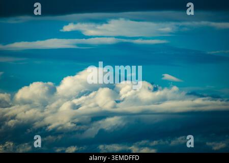 A stunning view of fluffy white clouds floating across a brilliant blue sky, capturing the essence of nature's artistic beauty and boundless skies on Stock Photo
