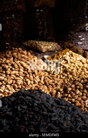 Close-up of heaps of dried fruit, nuts, and seeds displayed in a traditional market stall in Uzbekistan, Central Asia, showcasing local food trade and Stock Photo