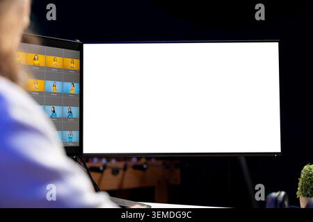 Photographer using photo editing software on mockup multi monitors setup to improve images quality. Photo editor utilizing pictures retouching application on isolated screen display Stock Photo