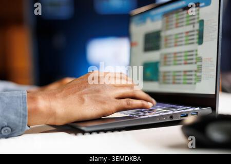 Financial analyst looking into business expenses and profit, trying to create a balance between cost and revenue to help with capital growth. African american man examines economic reports. Close up. Stock Photo